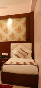a bedroom with a bed with a flowery wall at Hotel Varanasi Inn in Varanasi