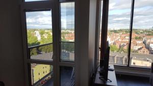 a room with three windows with views of a city at City Apartment in Klaipėda