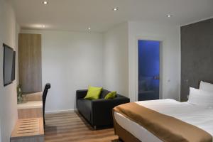 ein Hotelzimmer mit einem Bett und einem Sofa in der Unterkunft Hotel-Restaurant Kölbl in Enkenbach-Alsenborn