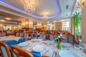 Hotel Polaris في سفينويتشي: غرفة طعام بها طاولات وكراسي وثريات