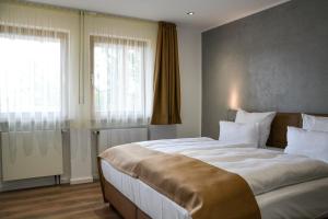 a bedroom with a large bed and a window at Hotel-Restaurant Kölbl in Enkenbach-Alsenborn +2 photos