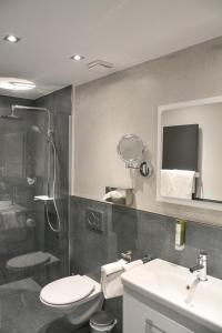 La salle de bains est pourvue de toilettes, d'un lavabo et d'une douche. dans l'établissement Hotel-Restaurant Kölbl, à Enkenbach-Alsenborn