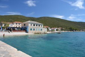 a building on the shore of a body of water at Apartman Valinor in Miholašćica