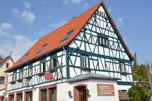 ein Fachwerkhaus mit orangefarbenem Dach in der Unterkunft Hotel-Restaurant Kölbl in Enkenbach-Alsenborn