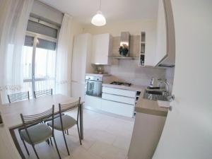 een keuken met een tafel, stoelen en een spoelbak bij Casa Claudia in La Spezia