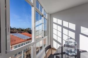 a room with a large window and a bird cage at Pensión O Castelo in Palas de Rei