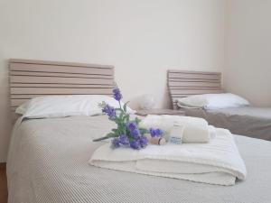ラ・スペツィアにあるCasa Claudiaのベッド(タオル付)、花束