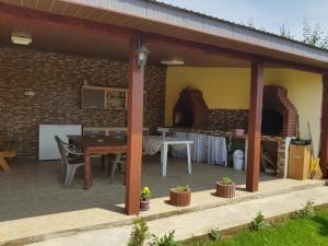 an outdoor patio with a table and a kitchen at Cazare Balliu in Corbu