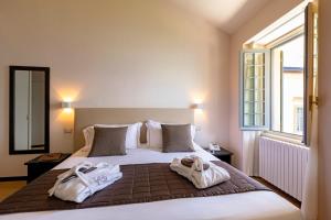 ヴァレンナにあるHotel Villa Cipressi, by R Collection Hotelsのベッドルーム1室(大型ベッド1台、タオル付)