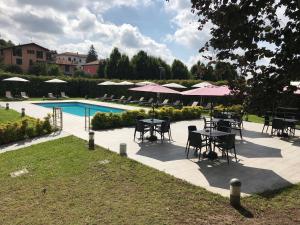 un patio avec des tables et des parasols à côté d'une piscine dans l'établissement Bis Hotel Varese, à Varèse