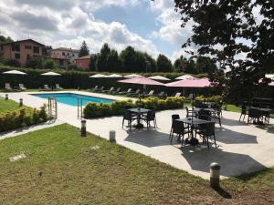 a patio with tables and umbrellas next to a pool at Bis Hotel Varese in Varese