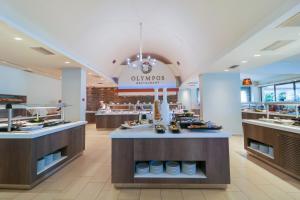 a restaurant with a counter in the middle at Olympian Bay Grand Resort by Anayia All Inclusive Resorts in Leptokarya