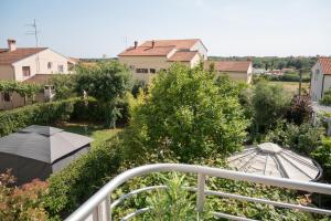 - Balcón con vistas a un jardín con sombrillas en PaKua apartments & Penthouse, en Rovinj
