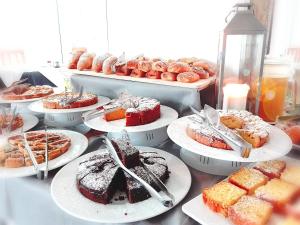 - une table avec des assiettes de desserts et des pâtisseries dans l'établissement Hotel Sogno, à Cesenatico