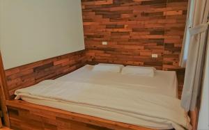 Ce lit se trouve dans une chambre dotée d'un mur en briques. dans l'établissement 海景擁月星宿民宿, à Chenggong