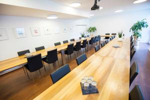 ein großer Konferenzraum mit einem langen Tisch und Stühlen in der Unterkunft Gyger Restaurant Confiserie B&B in Thusis