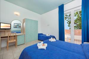 a bedroom with a blue bed and a balcony at Hotel Sogno in Cesenatico
