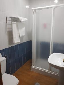 y baño con ducha, aseo y lavamanos. en Hostal Hispalis, en Gandul