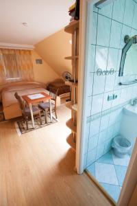 a small room with a table and a bathroom at Žvejo namas in Nida