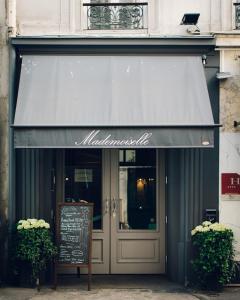a store front with a door open and a window at Hotel Mademoiselle in Paris