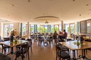people sitting at tables in a restaurant with windows at Ferienland Salem in Salem