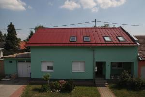 a green house with a red roof at Dalma in Osijek