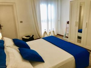 1 dormitorio con 1 cama grande con almohadas azules en Casa Vacanze Sonetto, en Maruggio