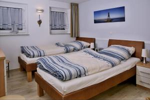 2 camas individuais num quarto com janelas em Duhnenperle em Cuxhaven