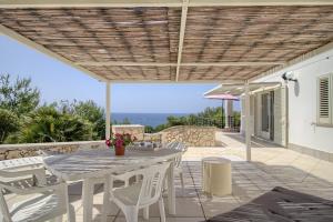 un tavolo bianco e sedie su un patio con vista di Scialandre by LoveSud a Patù