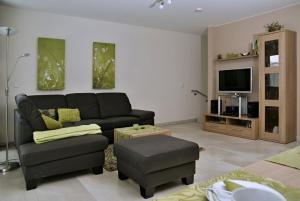 uma sala de estar com um sofá e uma televisão em Duhnenperle em Cuxhaven