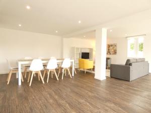 a dining room with a table and chairs and a couch at Gui'Home in Durbuy