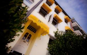 wysoki biały budynek z żółtymi drzwiami i oknami w obiekcie Hotel Carlton Mayfair w mieście Düsseldorf