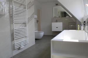 ein weißes Bad mit einem WC und einem Waschbecken in der Unterkunft Landhaus Almyssen in Alsbach