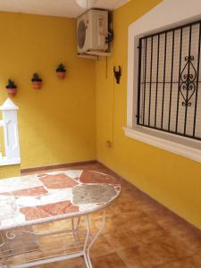 une chambre avec une table et un mur jaune dans l'établissement Calle Miguel Delibes, à San Bartolomé
