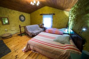 ein Schlafzimmer mit einem Bett und einem Stuhl in einem Zimmer in der Unterkunft Caserío da Castiñeira in Sas do Monte