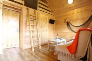 a room with a ladder in a wooden cabin at Domki Letniskowe Nad Morzem in Międzyzdroje