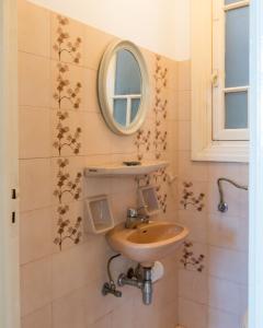 ein Bad mit einem Waschbecken und einem Spiegel in der Unterkunft Plaka Vintage in Athen