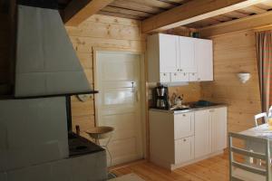 cocina pequeña con armarios blancos y fogones en Metsäpirtti en Kolinkylä