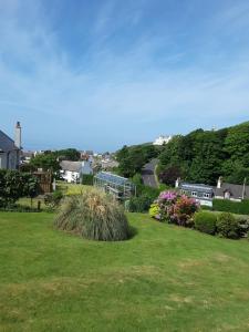uma vista para um quintal com relva e flores em Blinkbonnie Guest House em Portpatrick
