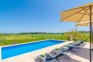 uma piscina com cadeiras e um guarda-sol em Es Pont Den Teulari Nou em Manacor