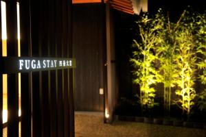 a street sign in front of a building with plants at FUGASTAY Shijo Omiya in Kyoto