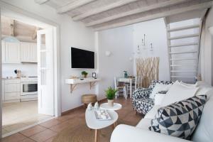 a white living room with a couch and a table at Panorea Complex - Mykonos in Ano Mera