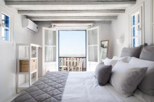 a bedroom with a bed with a view of the ocean at Panorea Complex - Mykonos in Ano Mera +36 photos