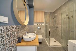 ein Badezimmer mit Waschbecken und Dusche in der Unterkunft Komfortowe Apartamenty Sun Seasons 24 w Pogorzelicy Blisko Morza by Noclegi Renters in Pogorzelica + 139 Fotos