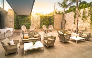 a patio with couches and chairs and tables at Hotel Cap Negret in Altea