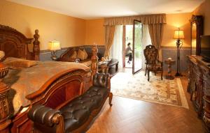 a bedroom with a bed and a desk and a chair at Landhaus Hotel Romantik in Gotha