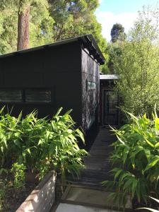 a black house with a wooden walkway at The Stewart in Margaret River Town