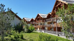 a row of apartment buildings with solar panels on their roofs at Les Sept Étoiles in Le Monêtier-les-Bains