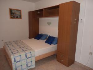 a bedroom with a bed and a wooden cabinet at Jandric Apartments in Lopar