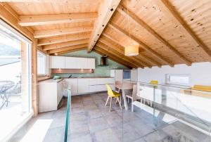 une cuisine et une salle à manger avec une table en verre et des chaises jaunes dans l'établissement Stay COOPER l Goethe Suite, à Bolzano